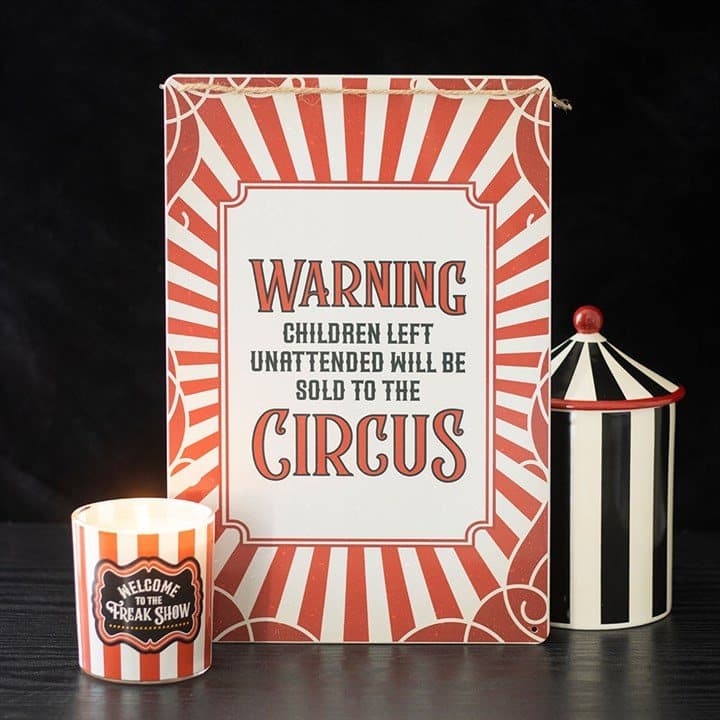 Striped metal hanging sign with a circus warning message
