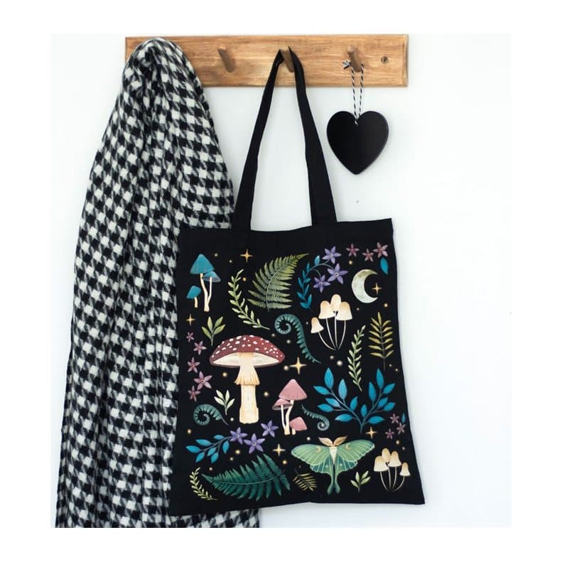 Black canvas tote bag printed with a dark forest, mushrooms and a luna moth