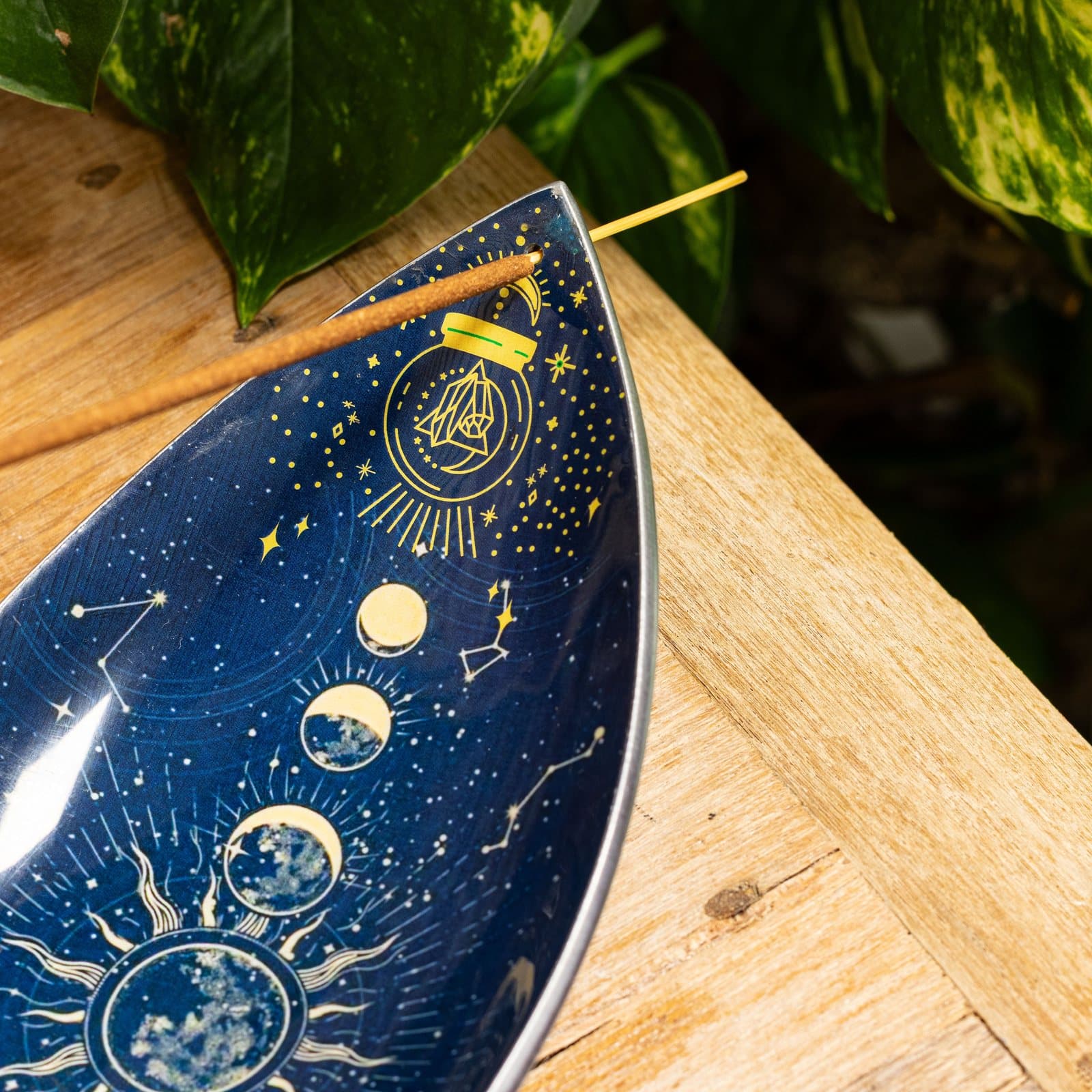 Enamel incense bowl with moon phases and zodiac symbols in gold on a dark background