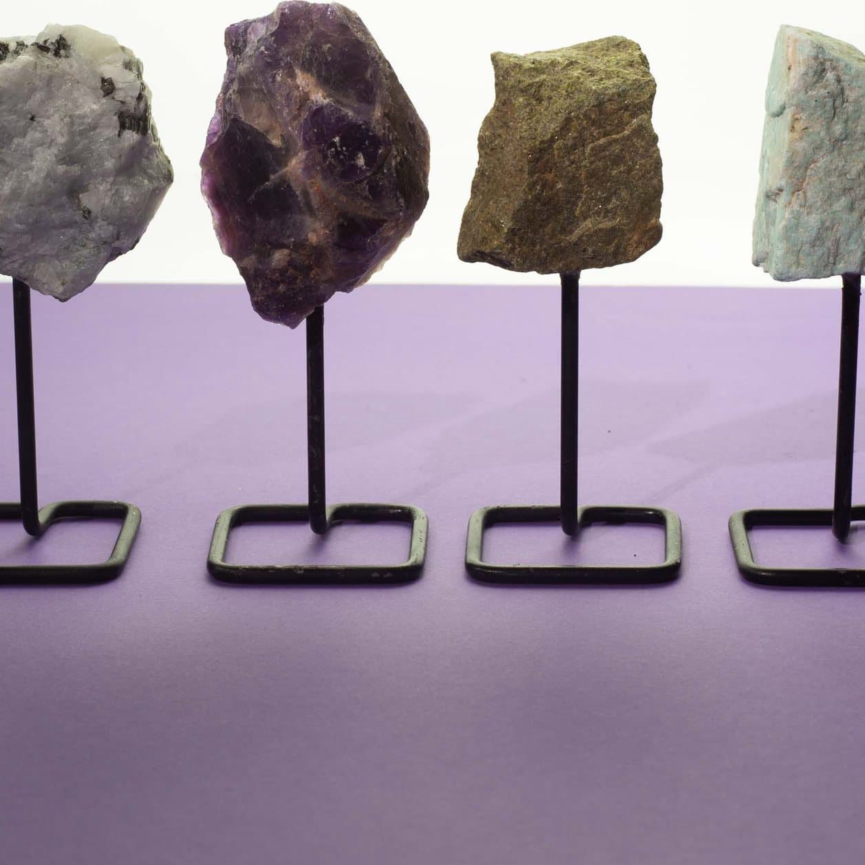 Raw green-brown epidote mineral specimen mounted on a black metal stand