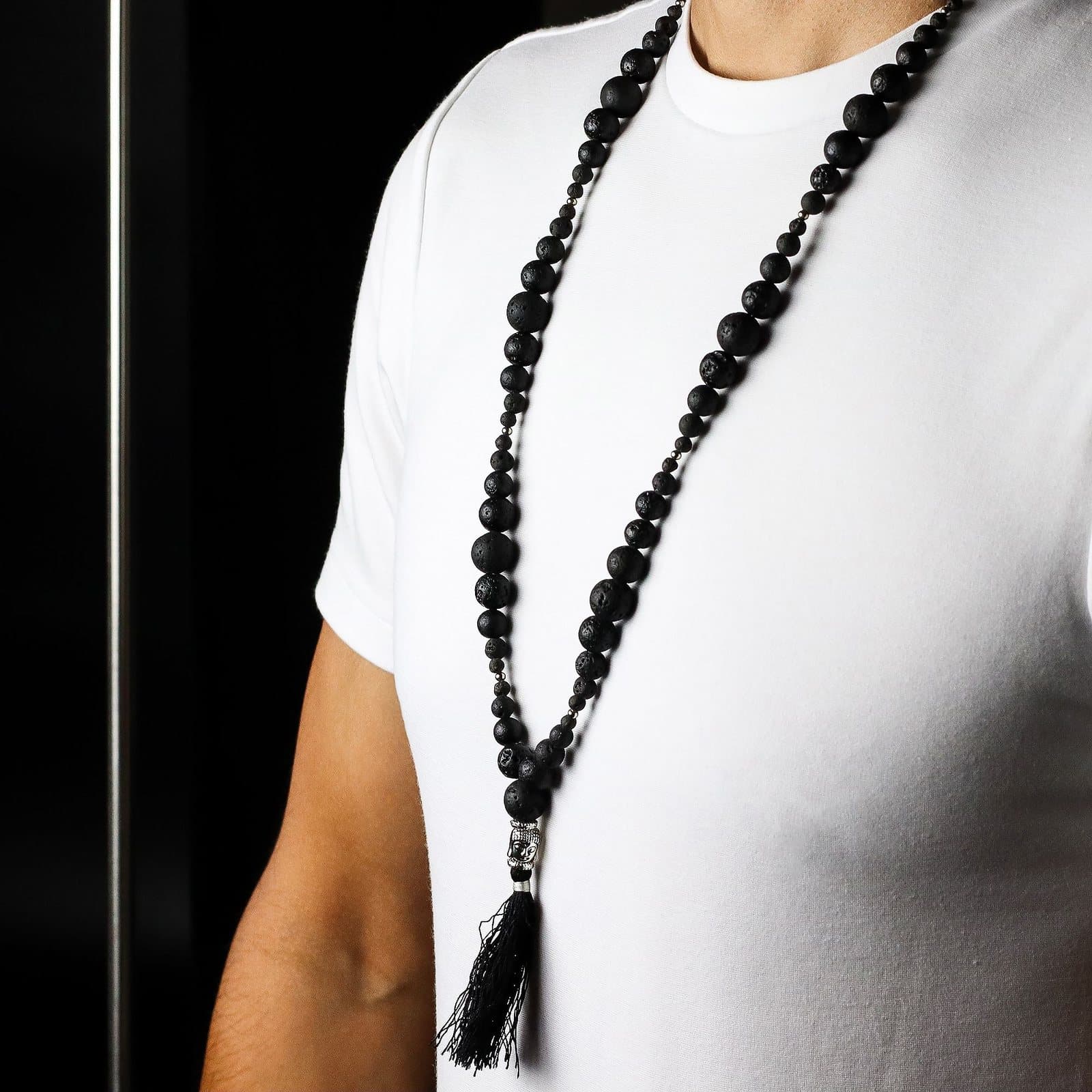 Lava stone necklace with a silver Buddha charm and soft tassel