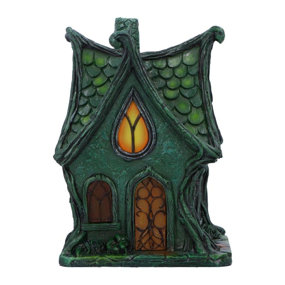 Dark green gothic fairy cottage with a pointed roof, vines and lit windows