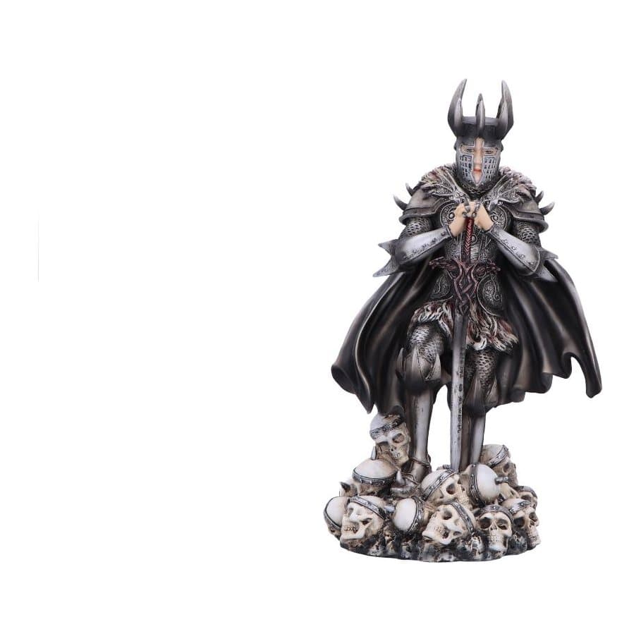 Gothic armoured knight figurine with sword standing over a pile of skulls