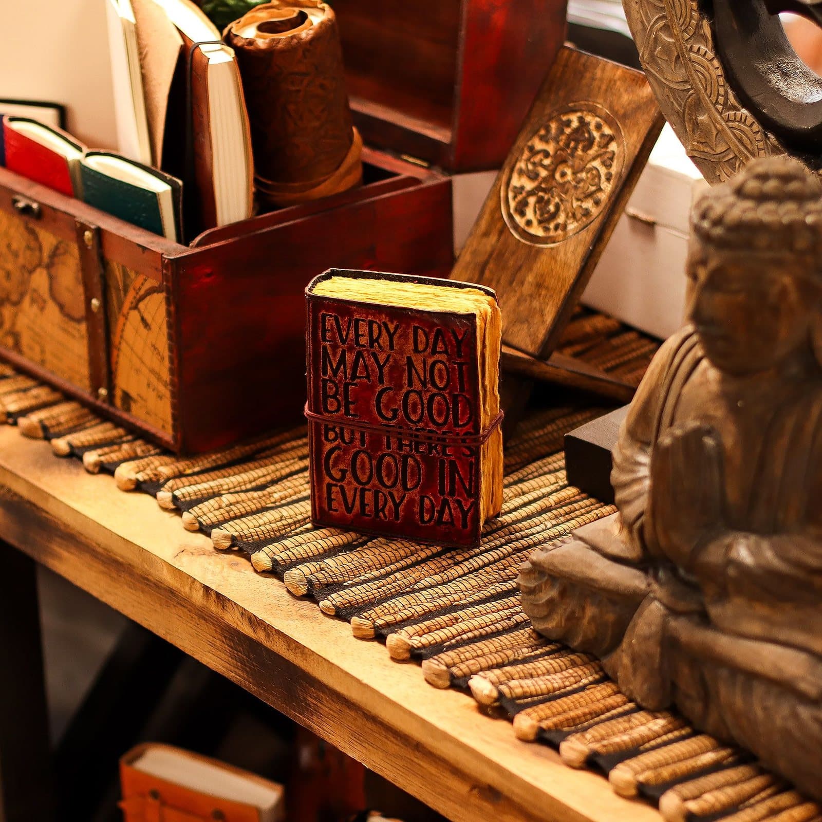 Pocket-sized brown leather notebook with embossed quote and tie closure