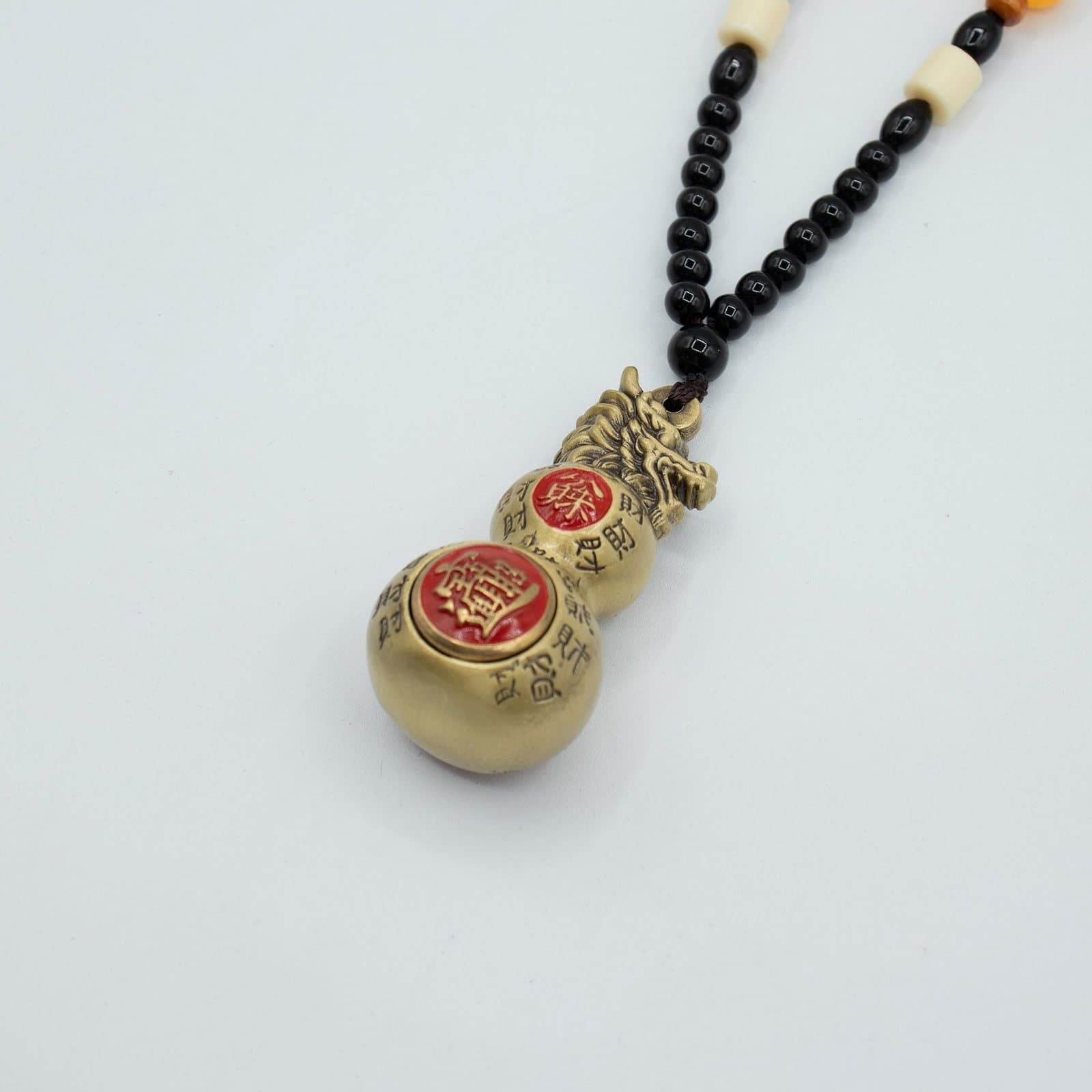 Brass double gourd with a dragon head hanging from a beaded cord