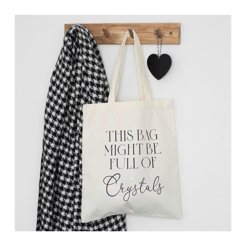 White canvas tote bag printed with 'This bag might be full of crystals'