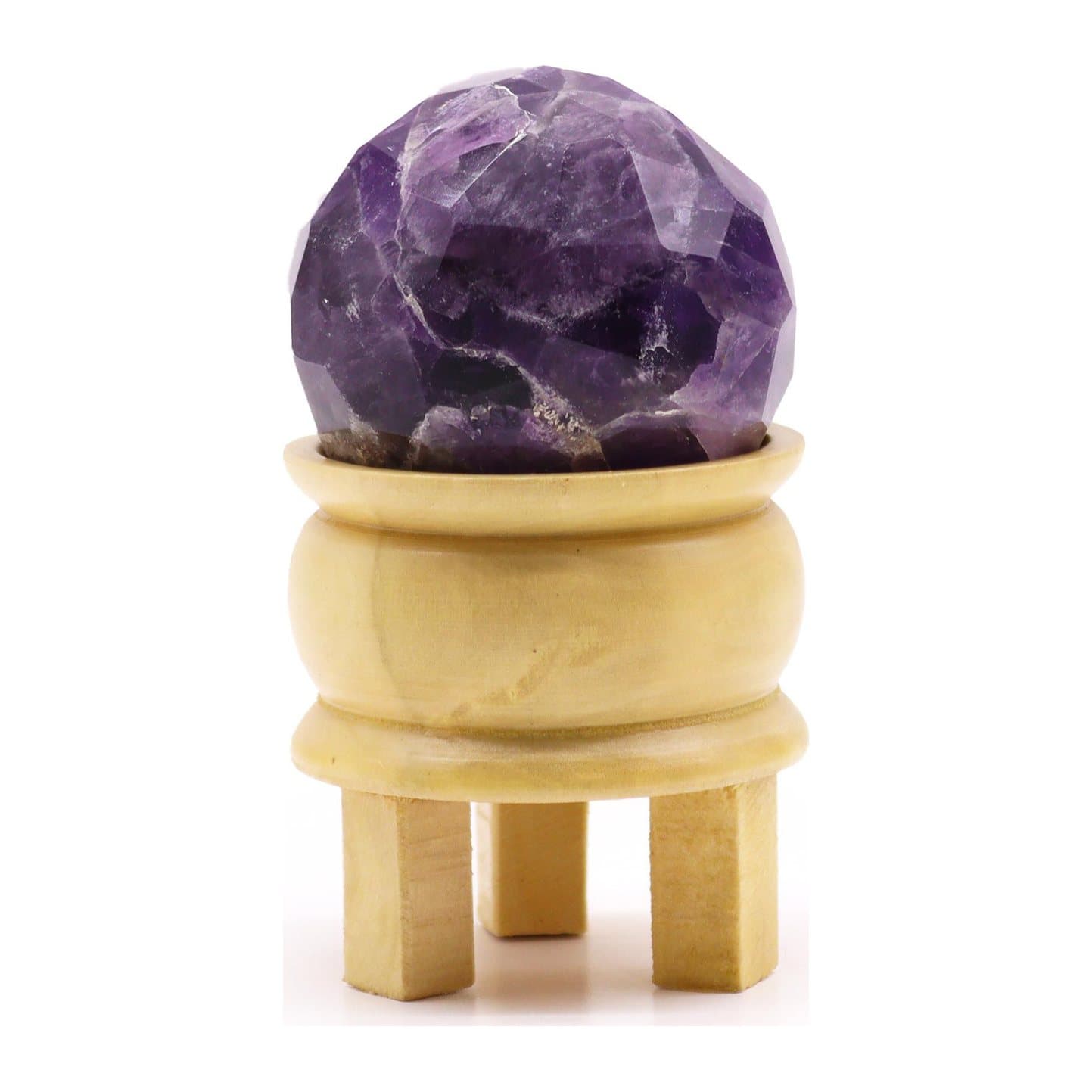 Faceted purple amethyst crystal ball on a light brown stand