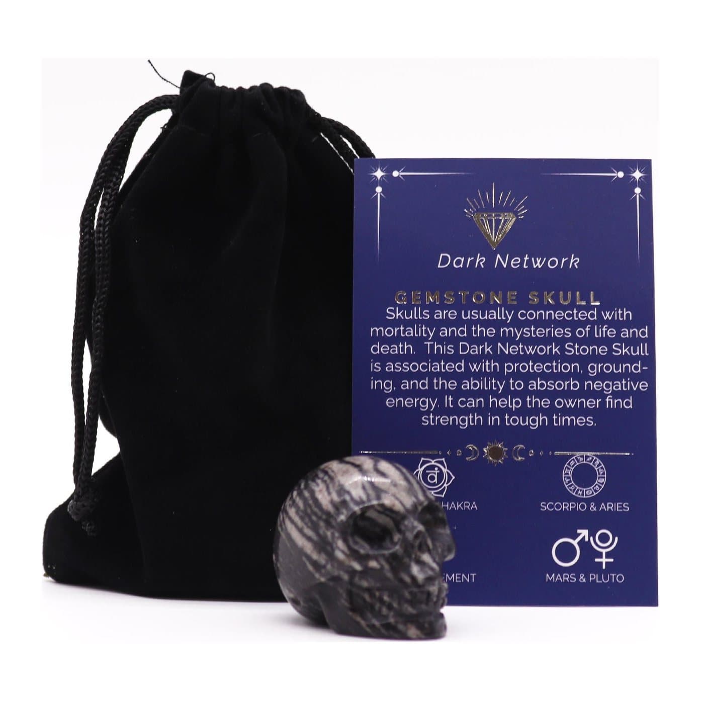 Small gemstone skull figure in dark network stone