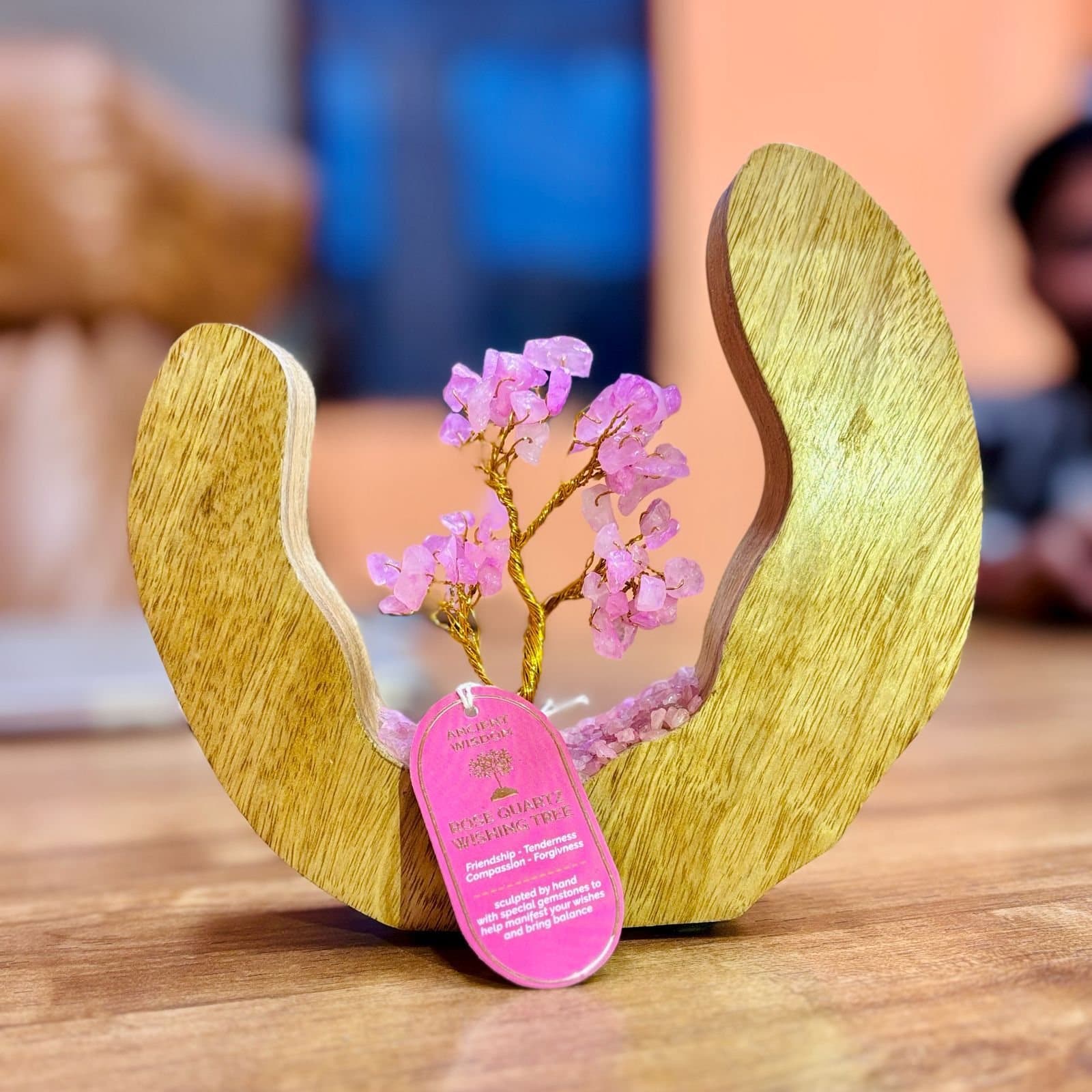Rose quartz gemstone tree inside an open mango wood ring