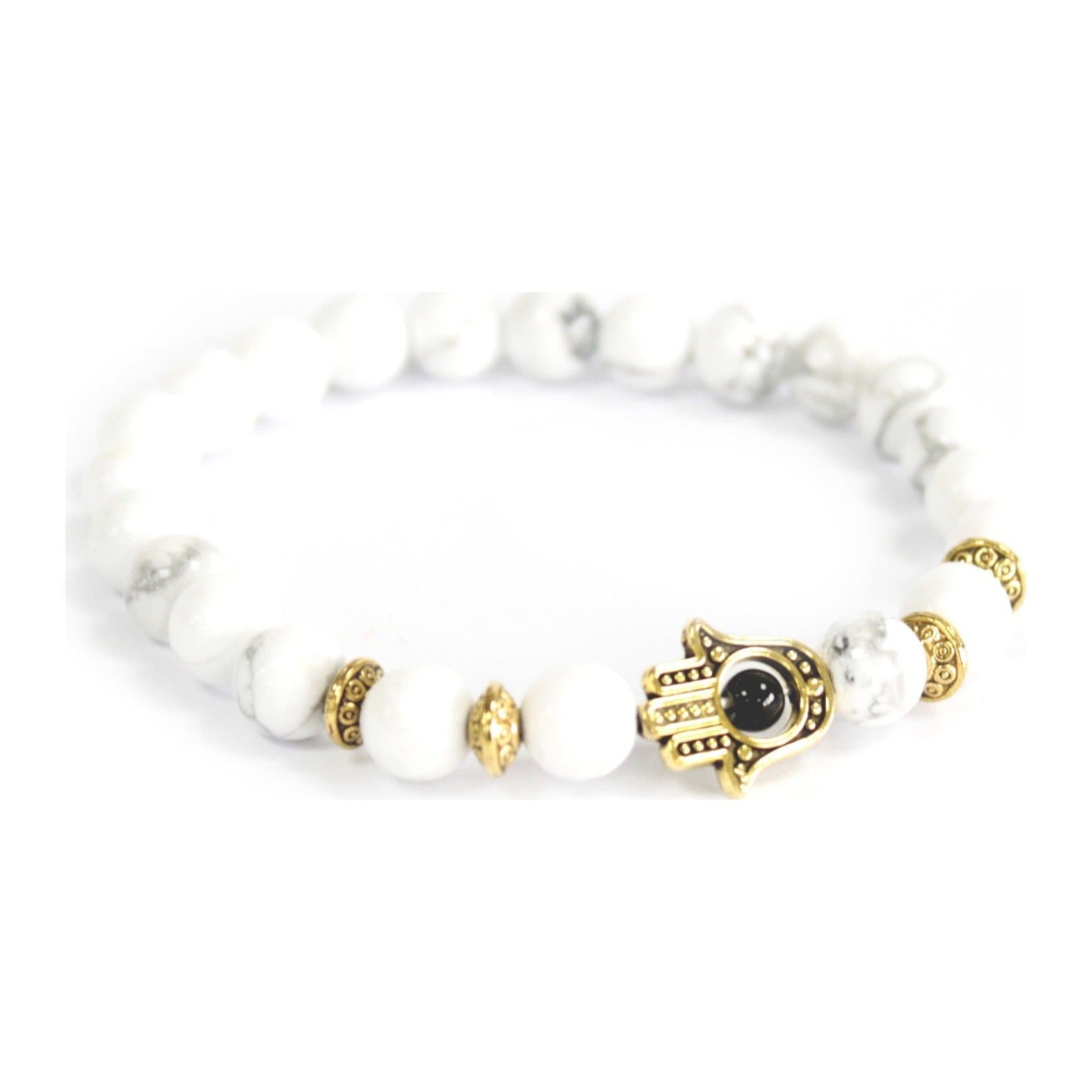 Stretch bracelet of white stone beads with a gold hamsa charm