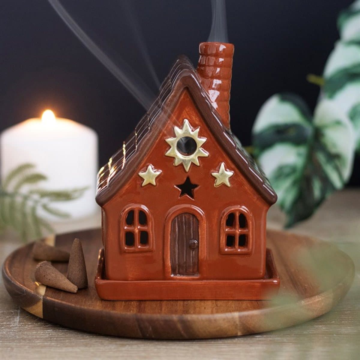 Terracotta-toned ceramic incense cone holder with sun motifs and a chimney