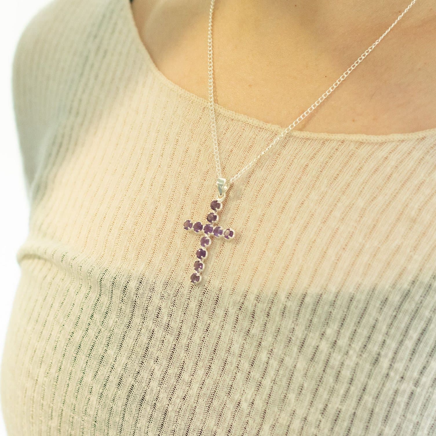 Silver crucifix pendant set with violet stones on a chain