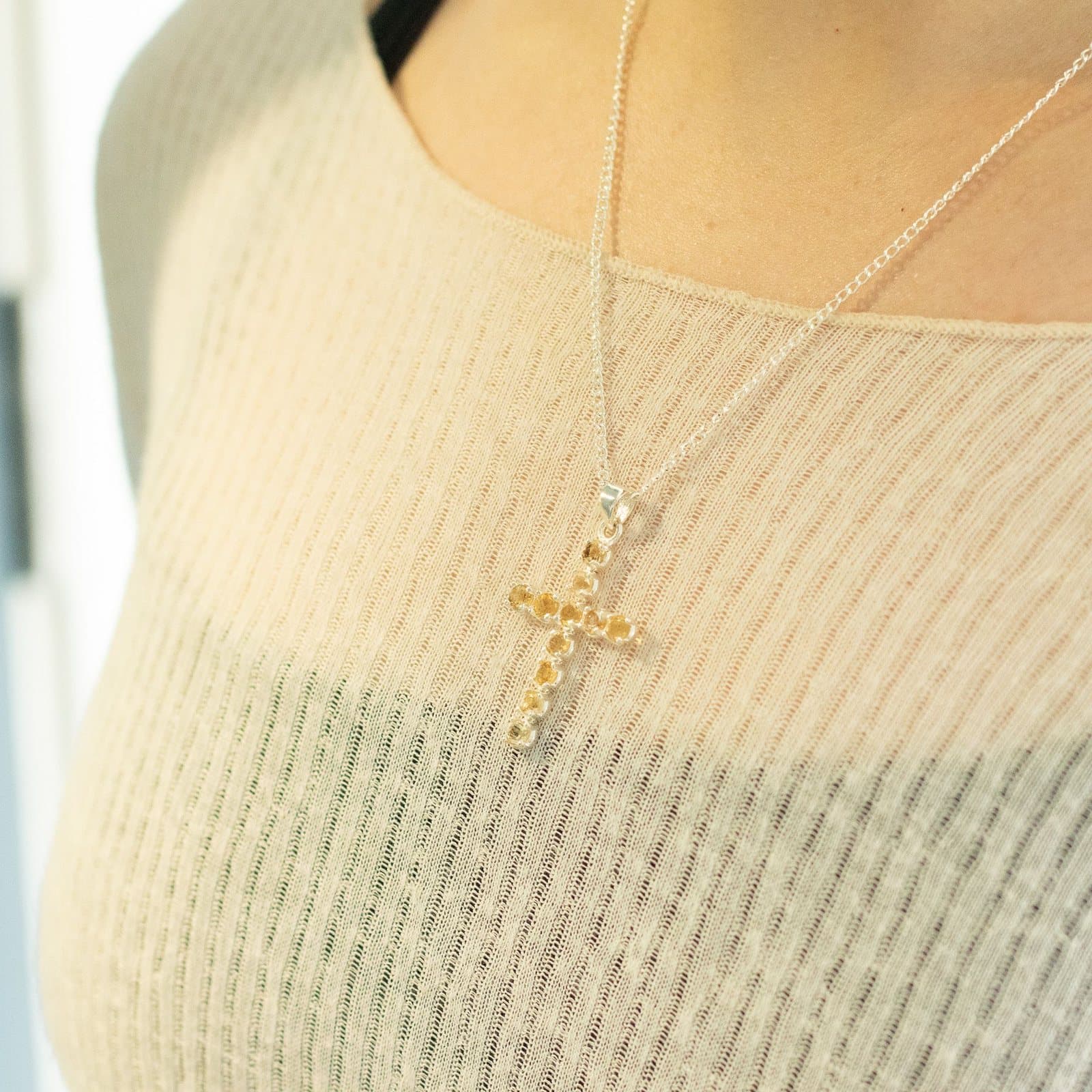 Silver-plated crucifix pendant set with golden faceted stones on a fine chain