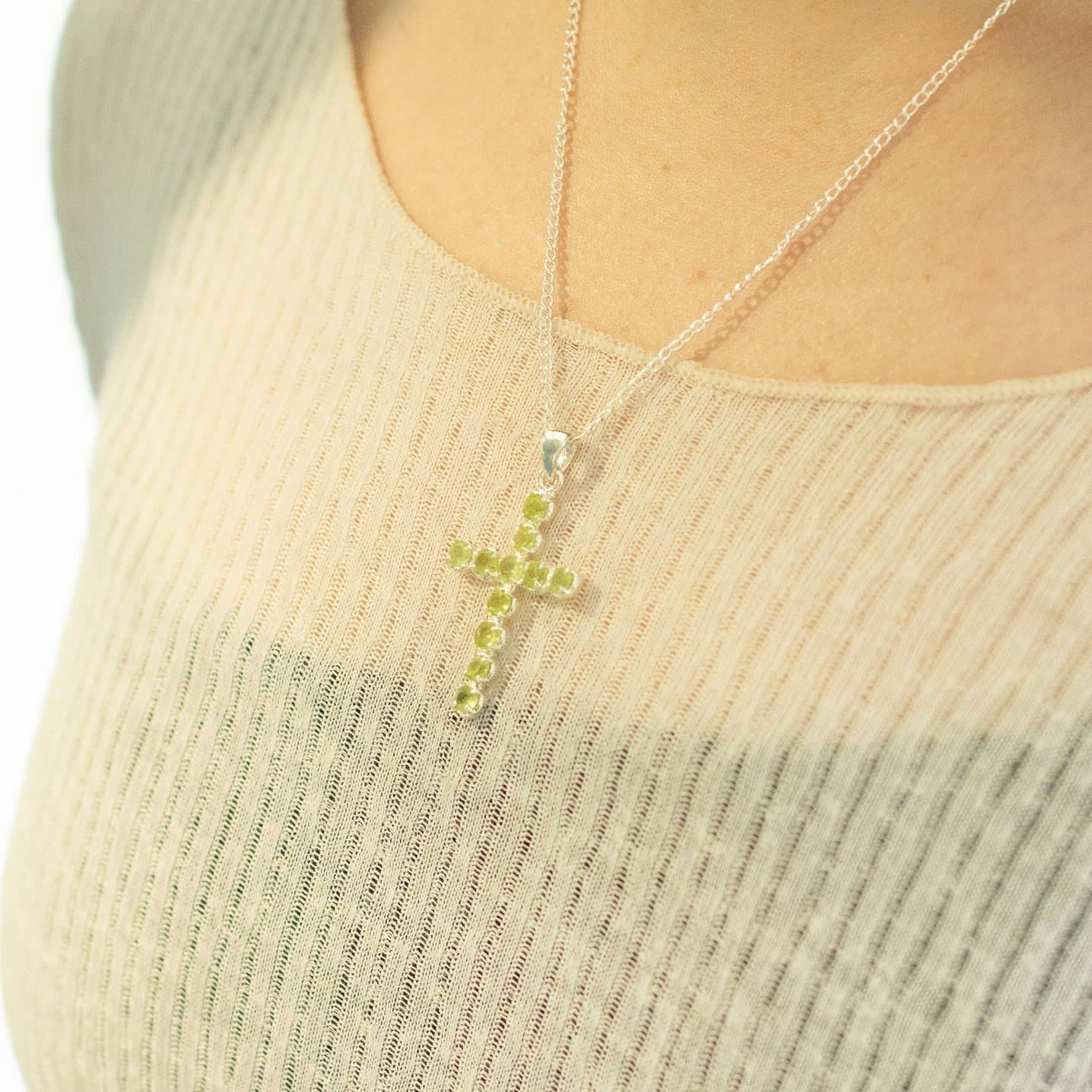 Silver-plated crucifix pendant with green stones on a fine chain