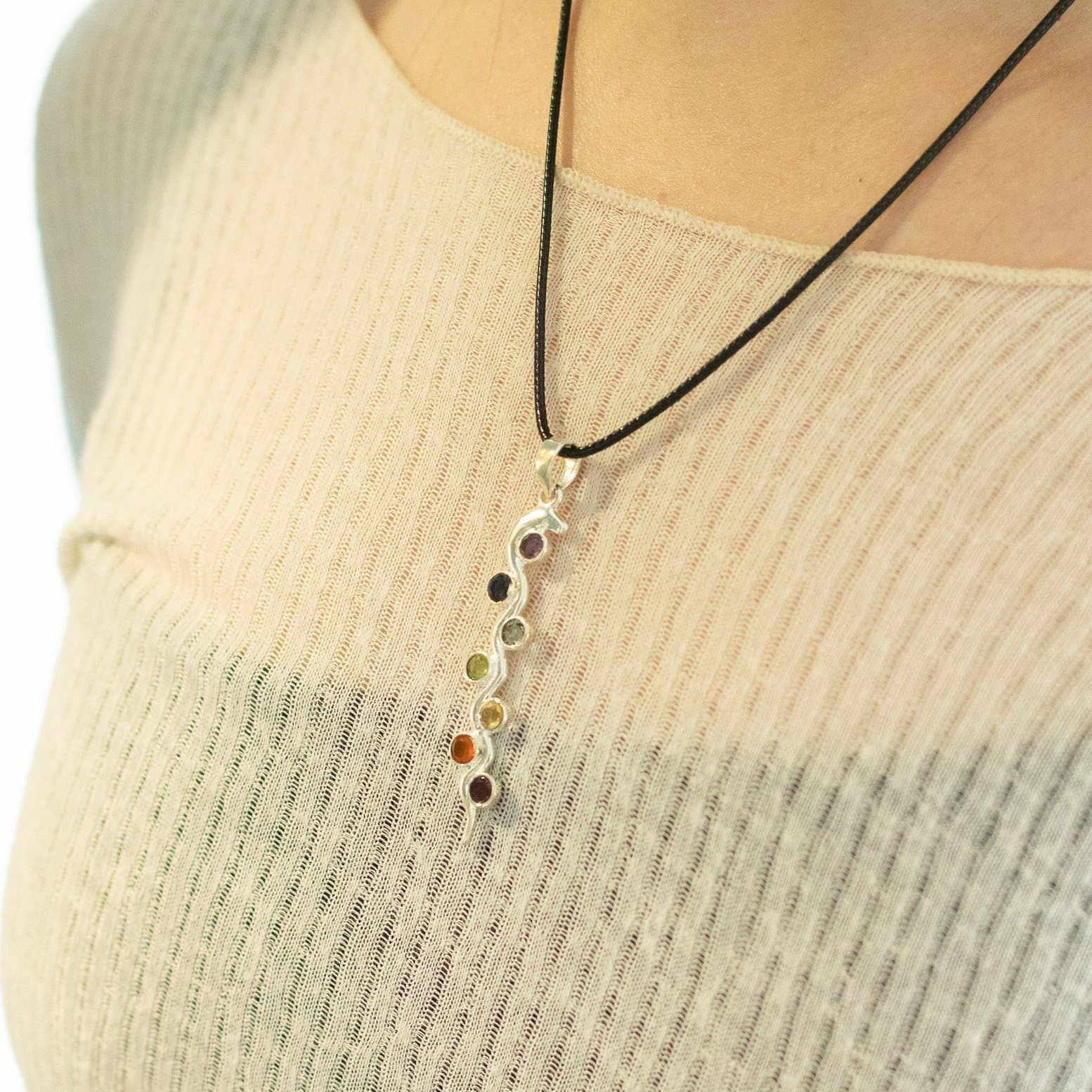 Silver plated chakra pendant with coloured stones on a black cord