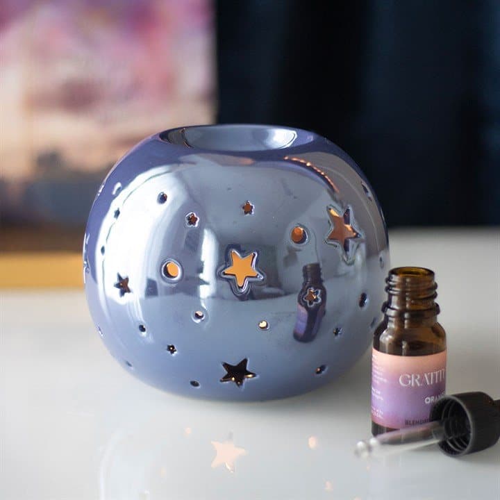 Iridescent ceramic star oil burner with star-shaped cut outs
