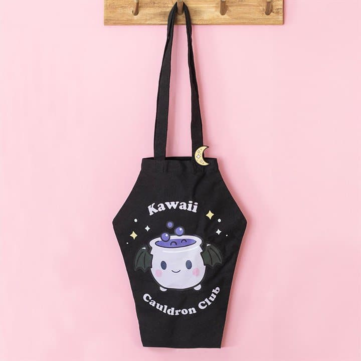 Coffin-shaped tote bag with a cauldron design and a crescent moon enamel pin