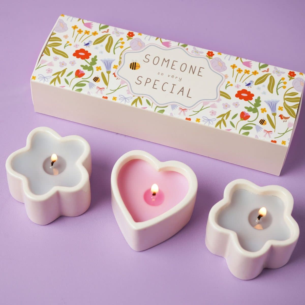 Three mini candles in heart and flower-shaped ceramic holders with patterned box