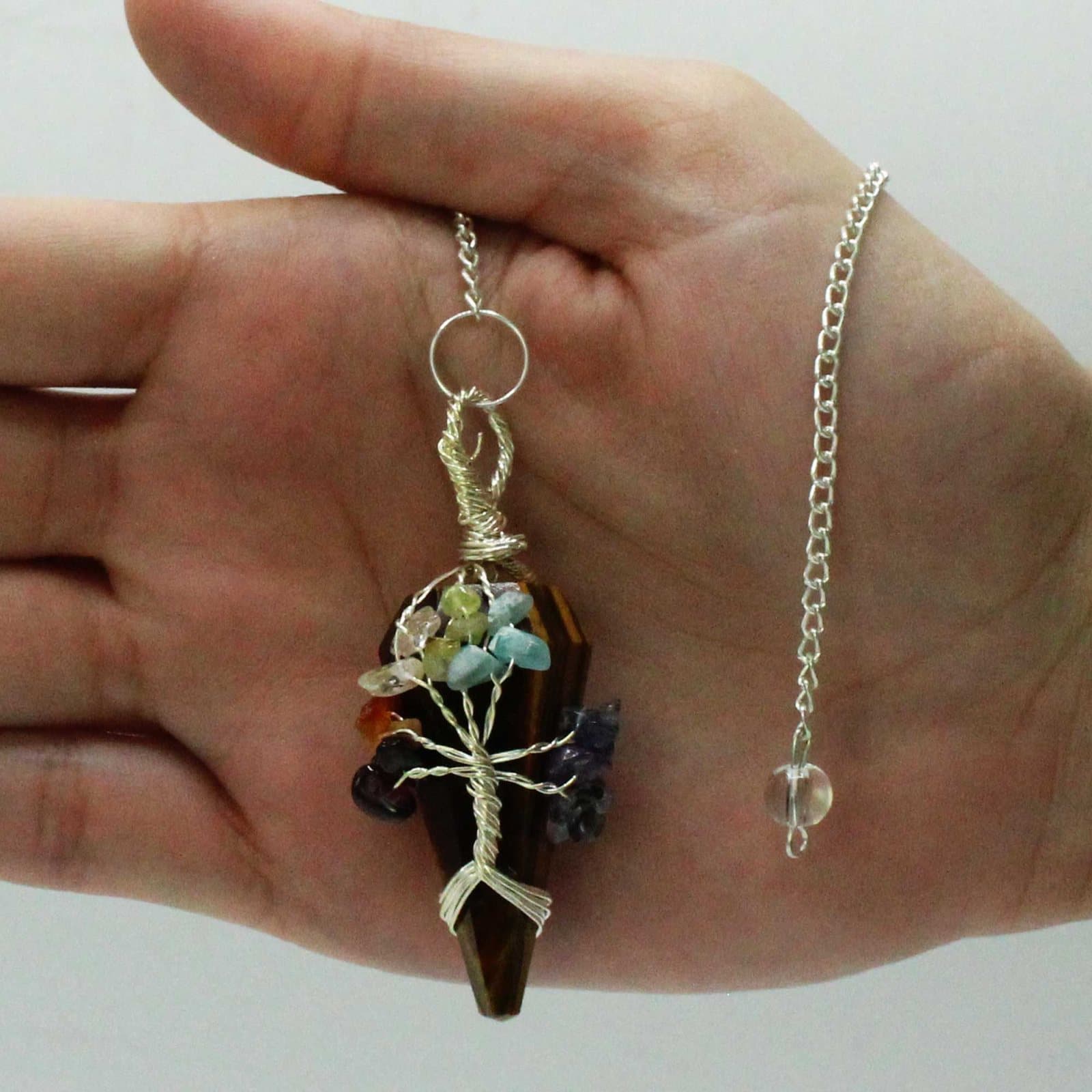 Seven chakra tigereye pendulum on a metal chain