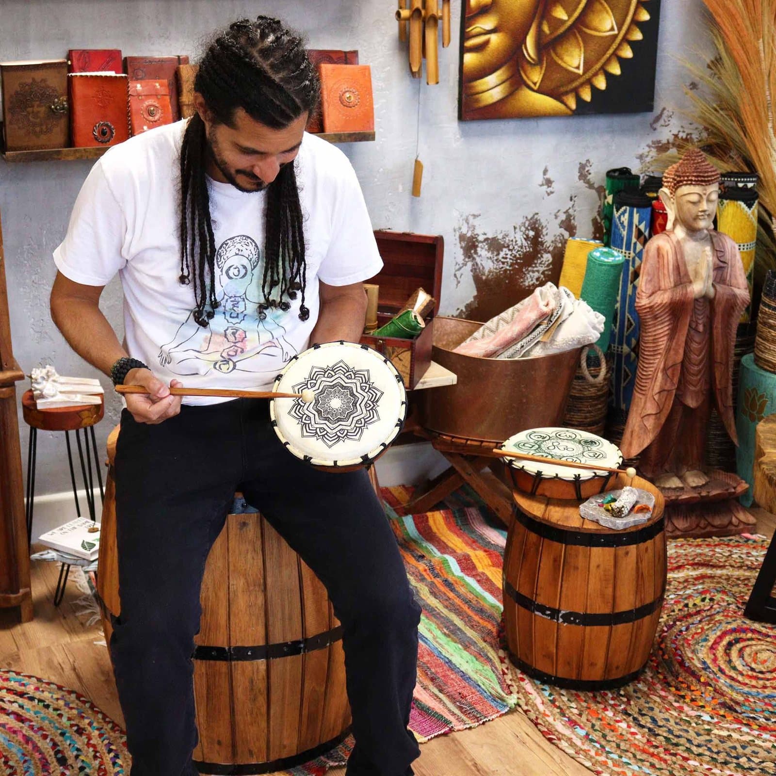 Round shamanic drum decorated with detailed mandala artwork, with a wooden beater
