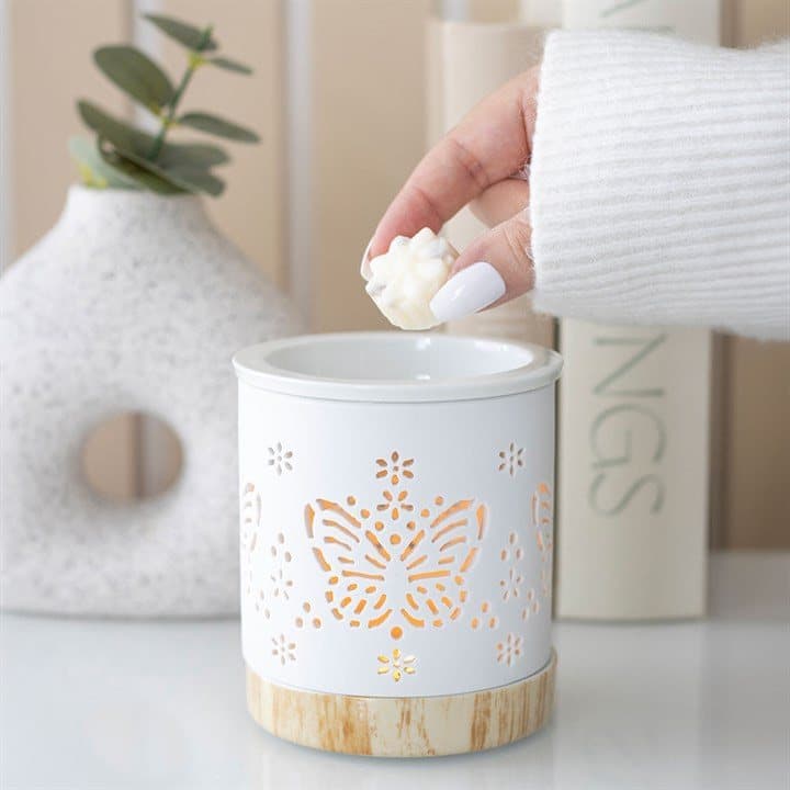 White matte ceramic oil burner with a cut-out butterfly pattern