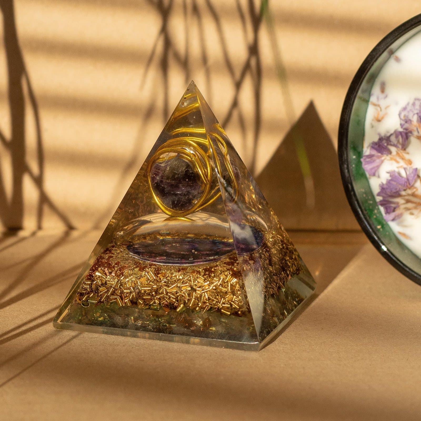 Medium orgonite pyramid with an amethyst crystal wrapped in golden wire