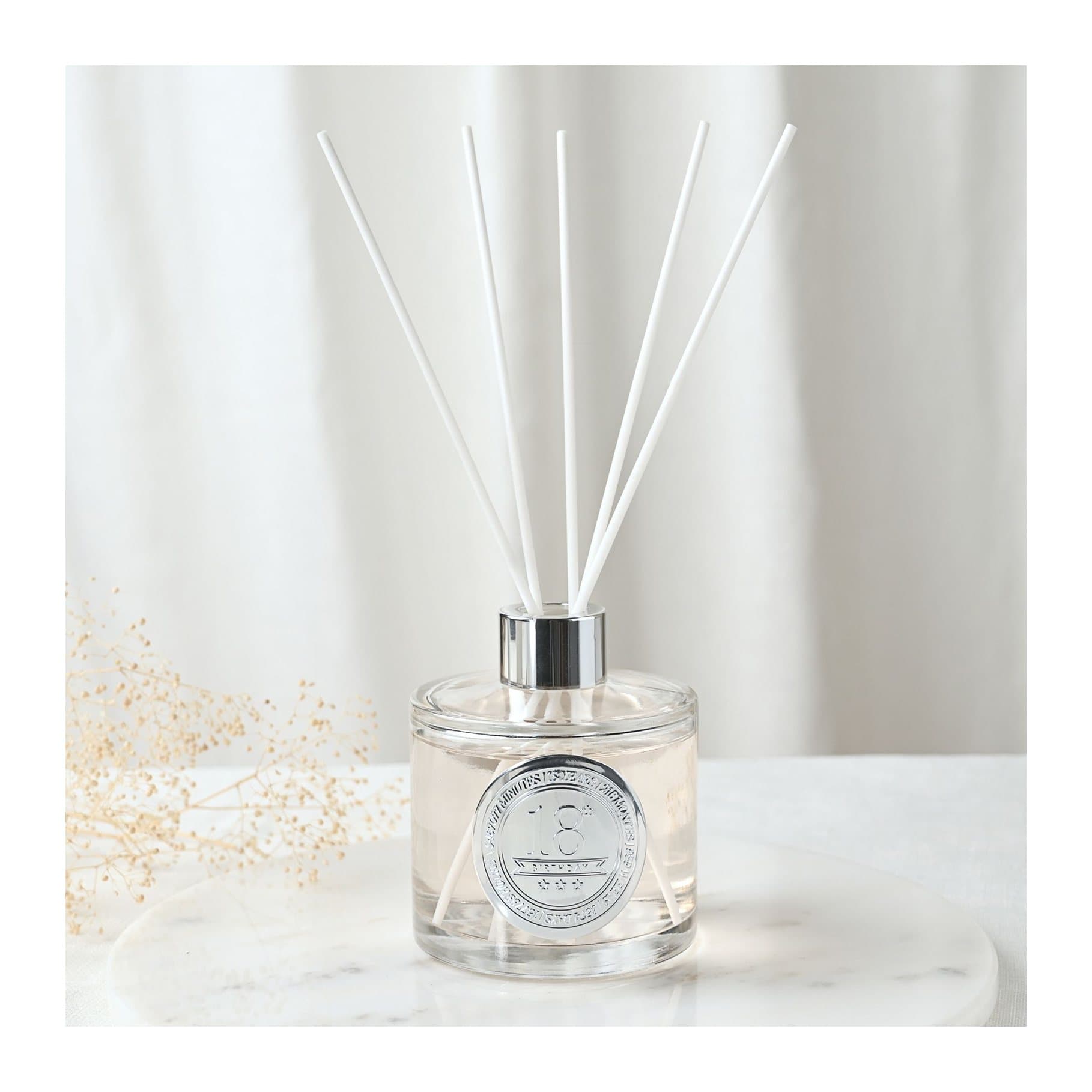 Clear glass diffuser with embossed 18 seal and white reed sticks