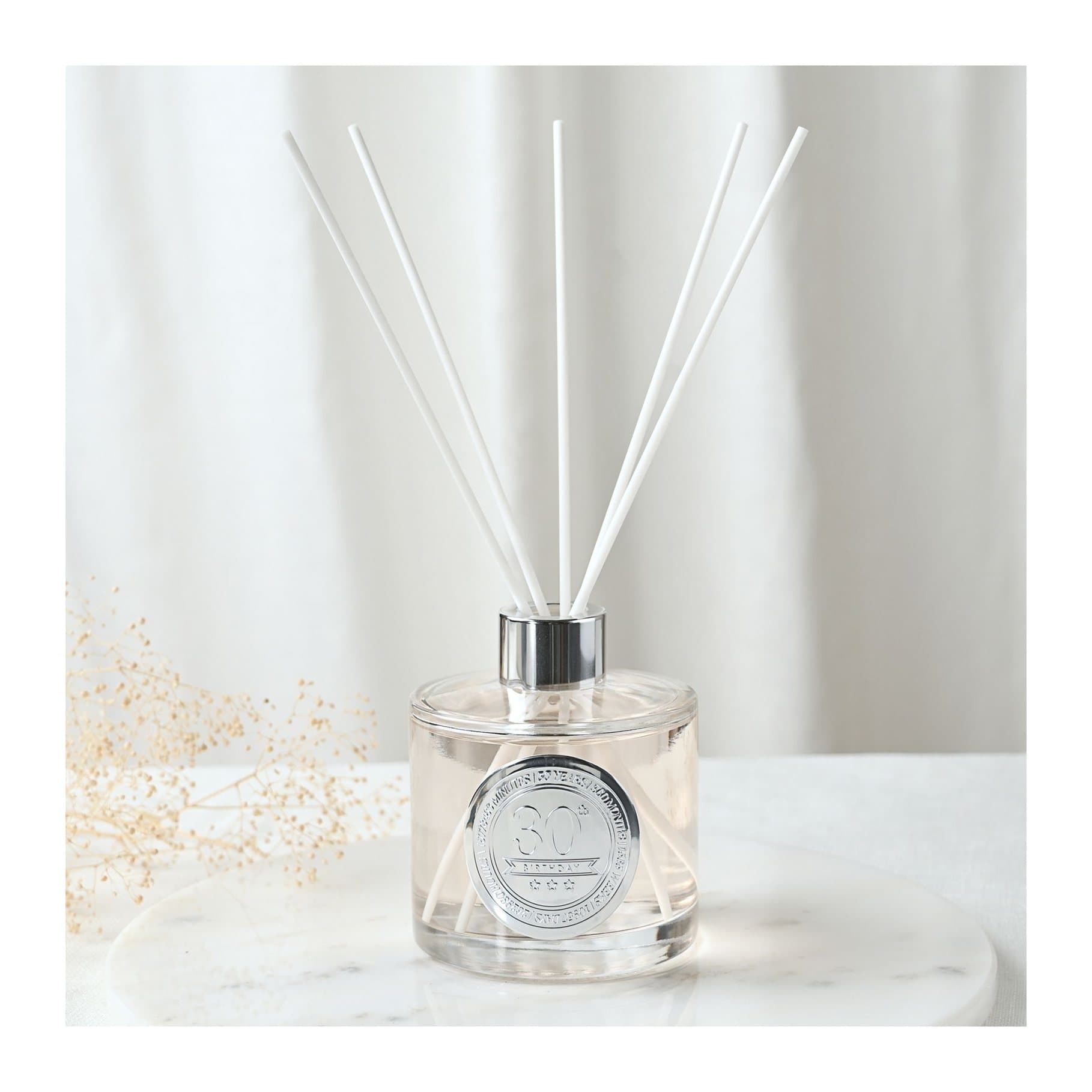 Clear glass sandalwood diffuser bottle with white reeds and an embossed 30 seal
