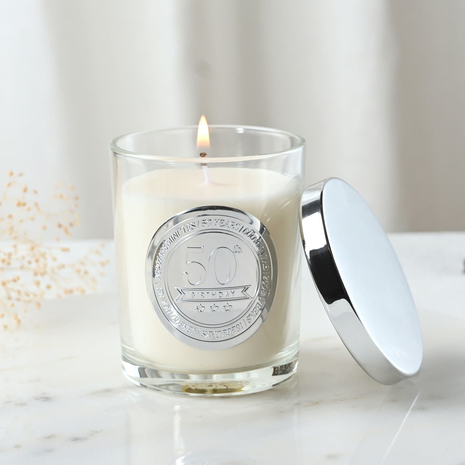 Sandalwood candle in a glass vessel with an embossed 50 seal and lid