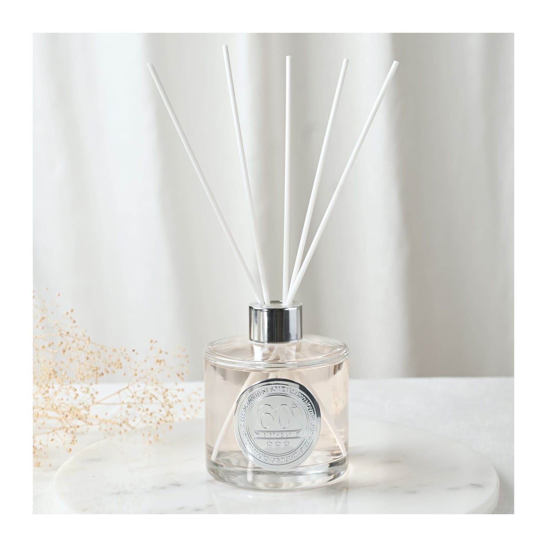 Clear glass sandalwood diffuser with embossed 60 seal and white reed sticks