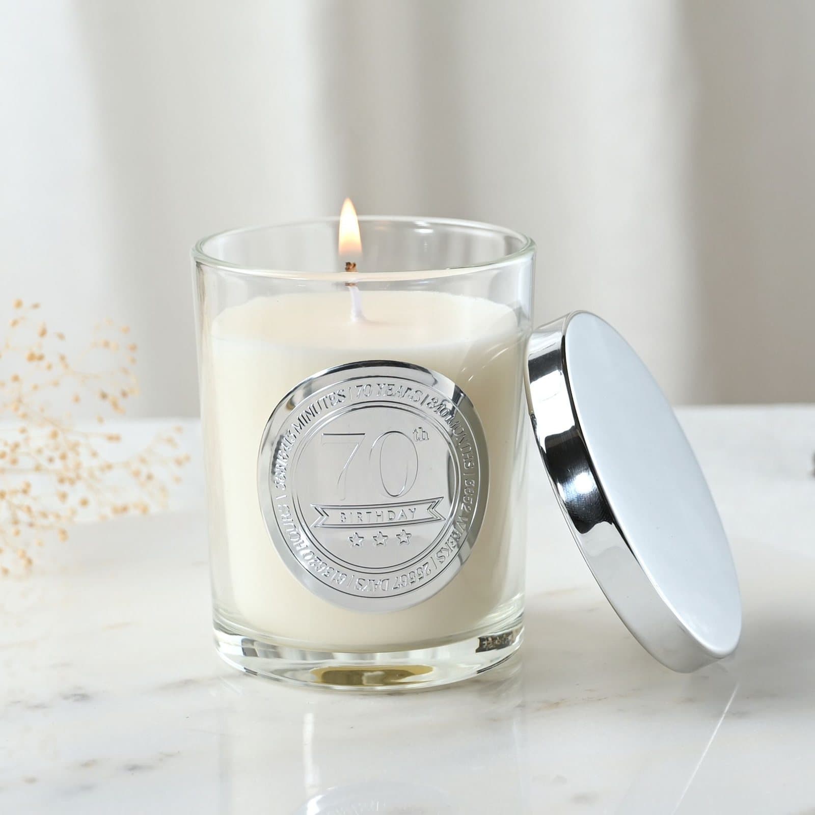 Sandalwood candle in a glass vessel with an embossed 70 seal and lid