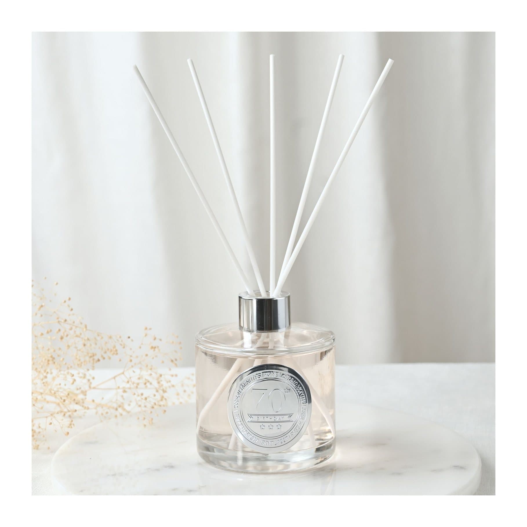 Clear glass sandalwood diffuser with embossed 70 seal and white reed sticks