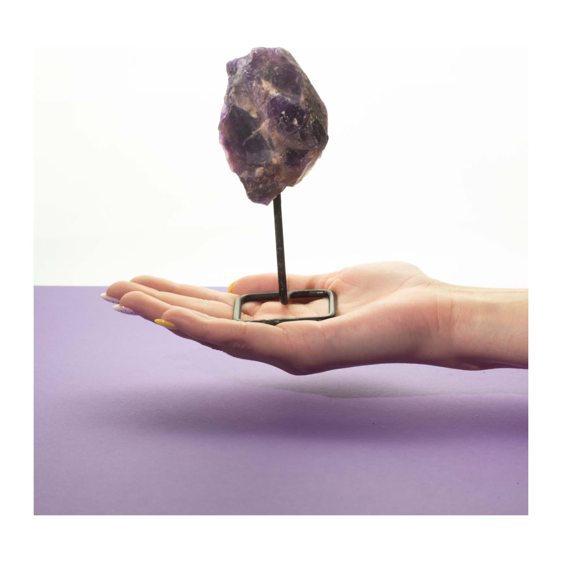 Raw purple amethyst specimen mounted on a simple black metal stand