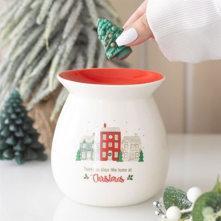 Ceramic wax warmer with a village scene and a green Christmas tree wax melt