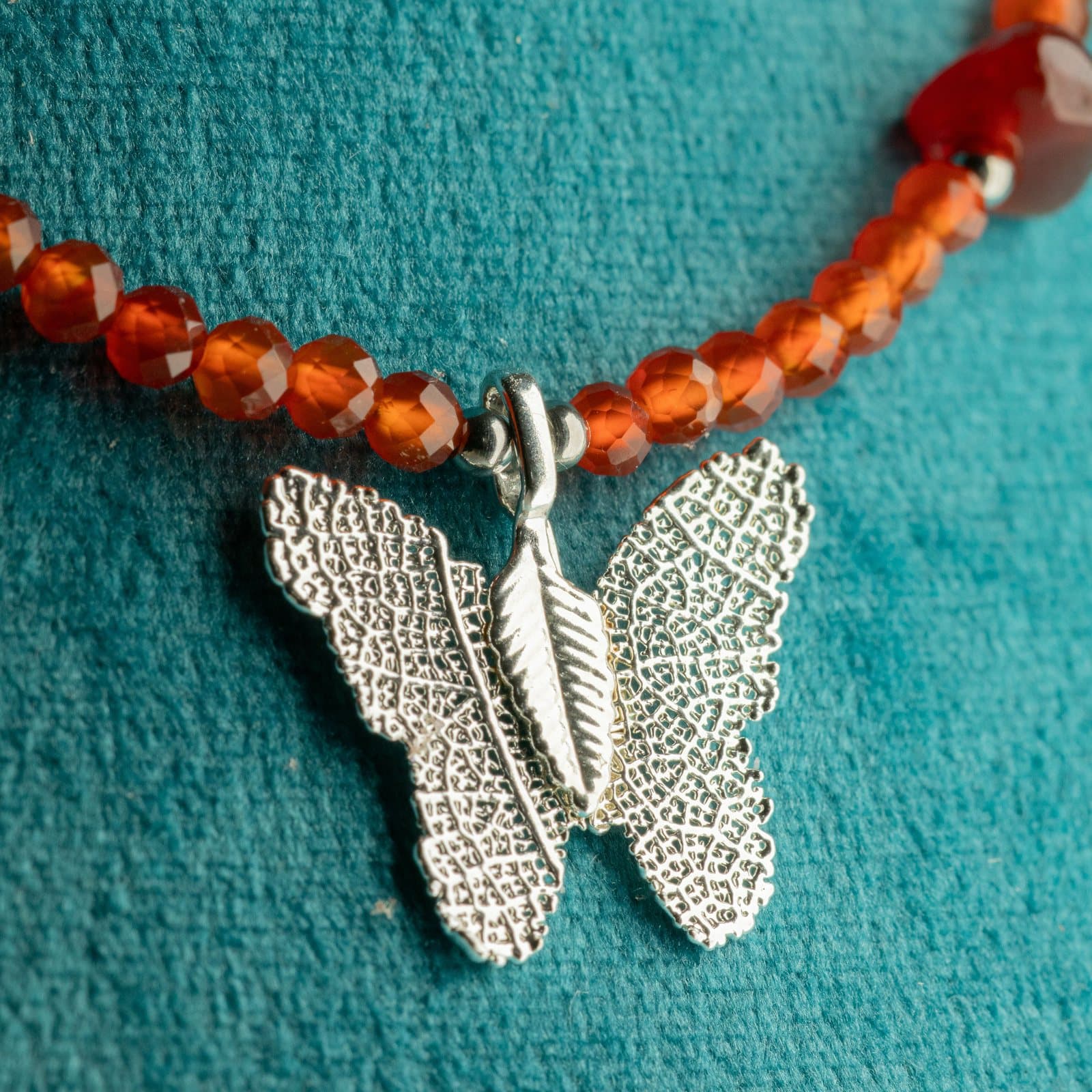 Ruby bead necklace with a silver-plated leaf butterfly pendant on a Nymph card