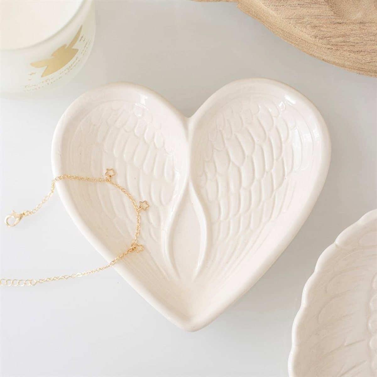 Off-white ceramic heart-shaped trinket dish with two angel wings