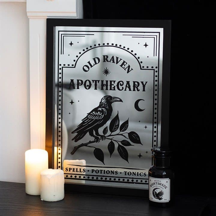 Mirrored wall art with an apothecary label, a raven and botanical designs