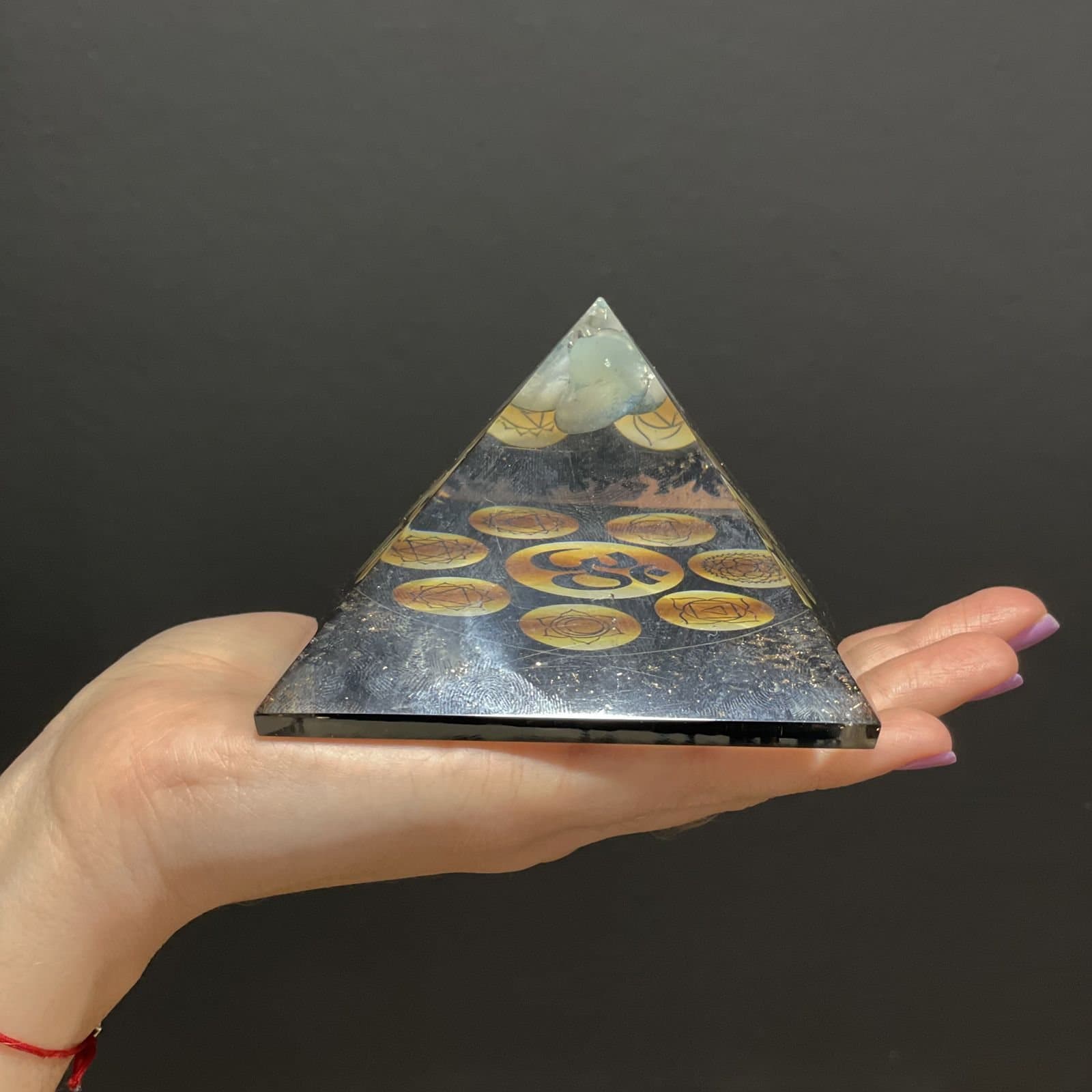 Orgonite pyramid of gemstone chips in resin with a chakra symbol