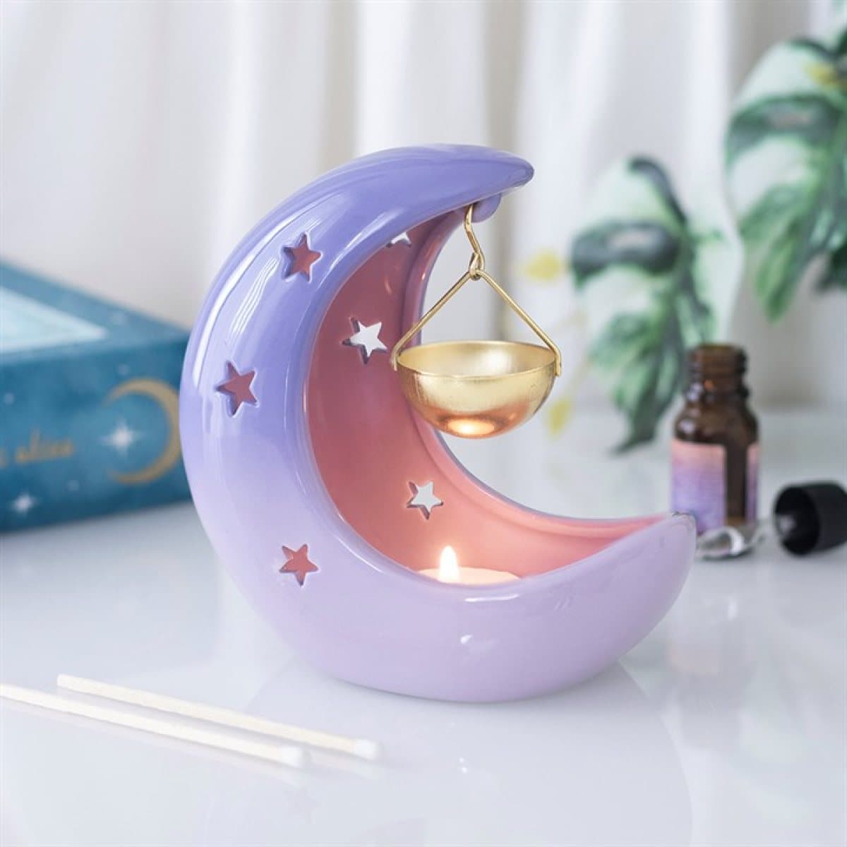 Pastel ceramic crescent moon oil burner with a hanging gold dish