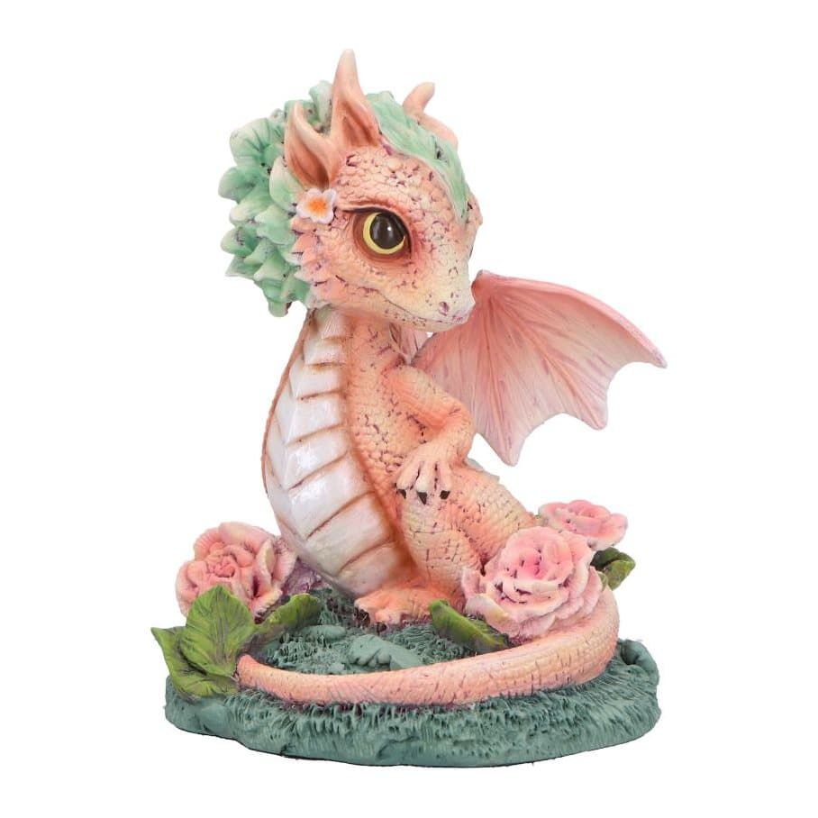 Baby dragon figurine with peach-pink scales on a mossy base with pink carnations