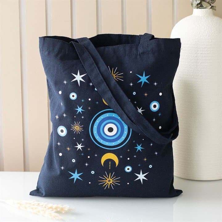 Dark blue tote bag with an all seeing eye, crescent moon and star design