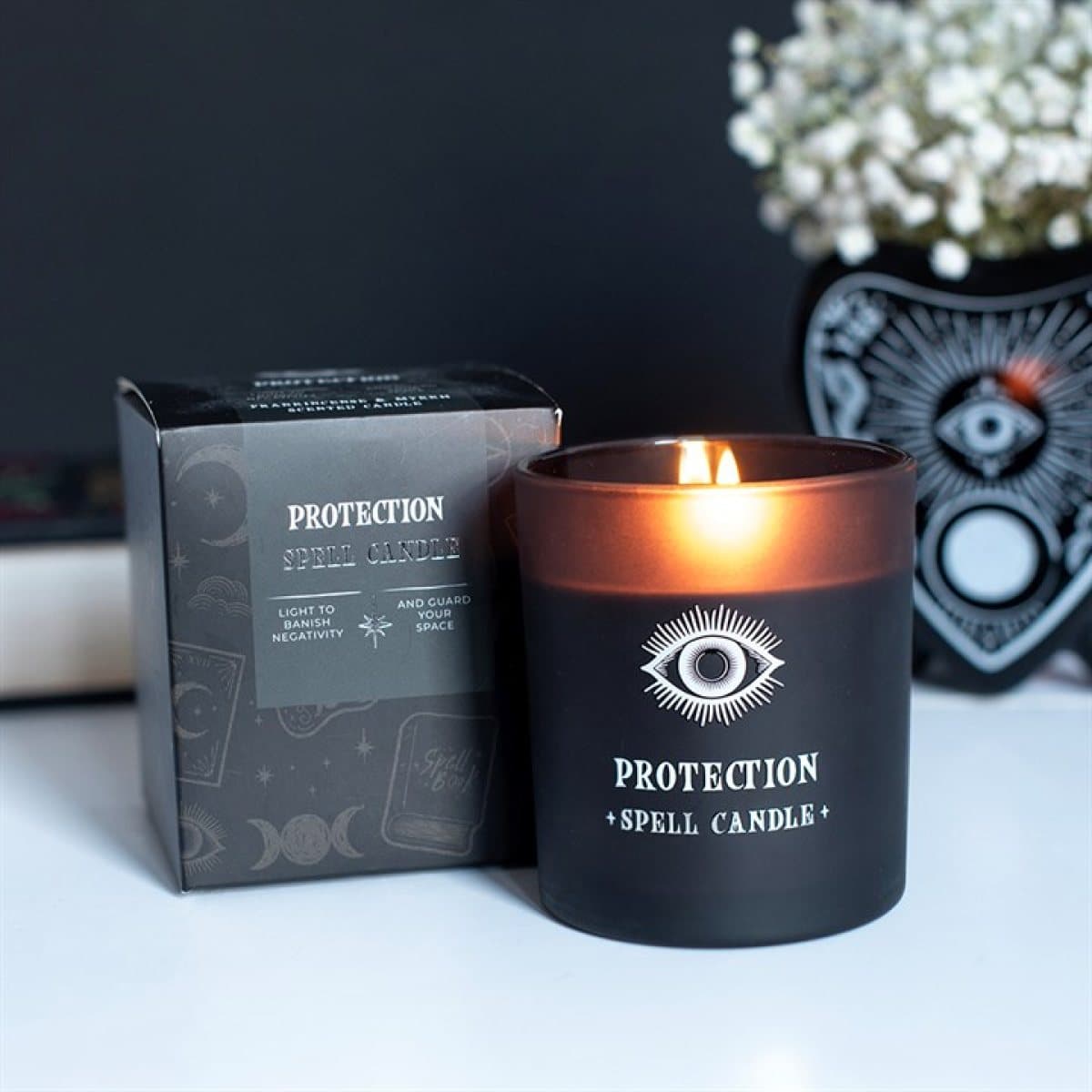 Black glass jar candle with an all-seeing eye design