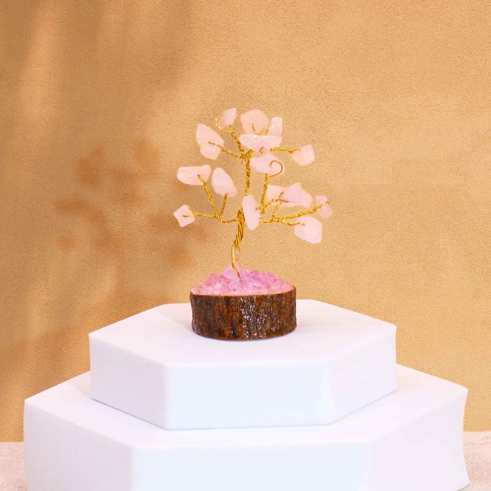 Mini rose quartz gemstone tree with pink stones on a wood base