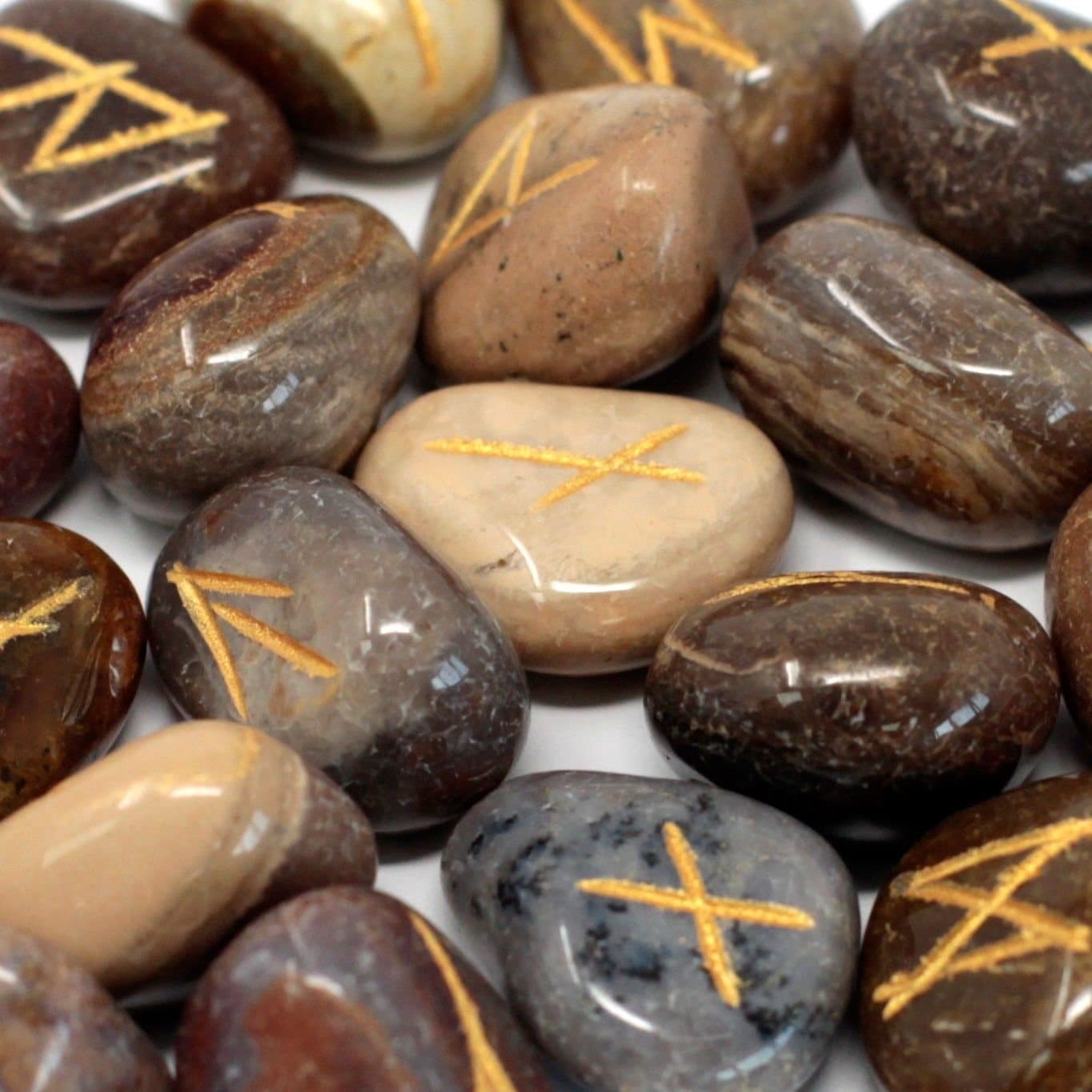 Fancy jasper rune stones marked with rune symbols beside their pouch