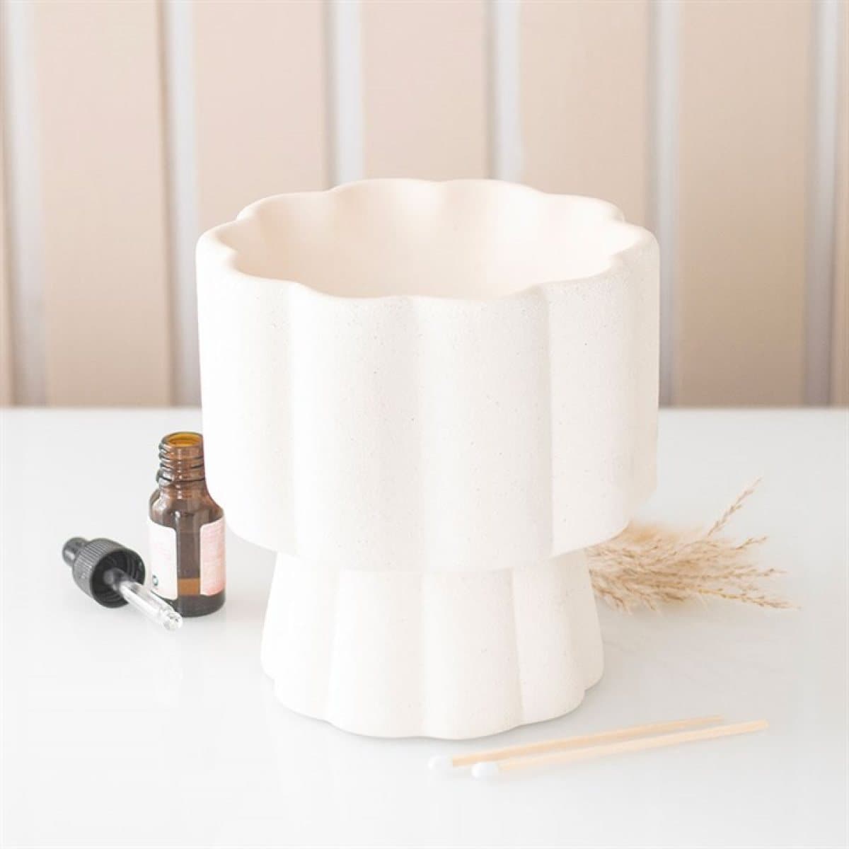 Ceramic oil burner with a scalloped edge and raised pedestal base