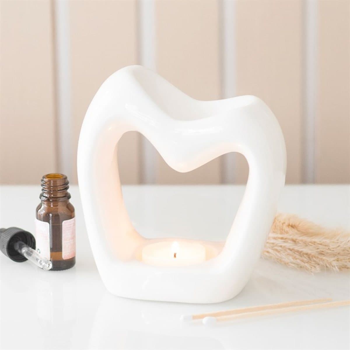 Glossy white ceramic oil burner with a cut-out heart design