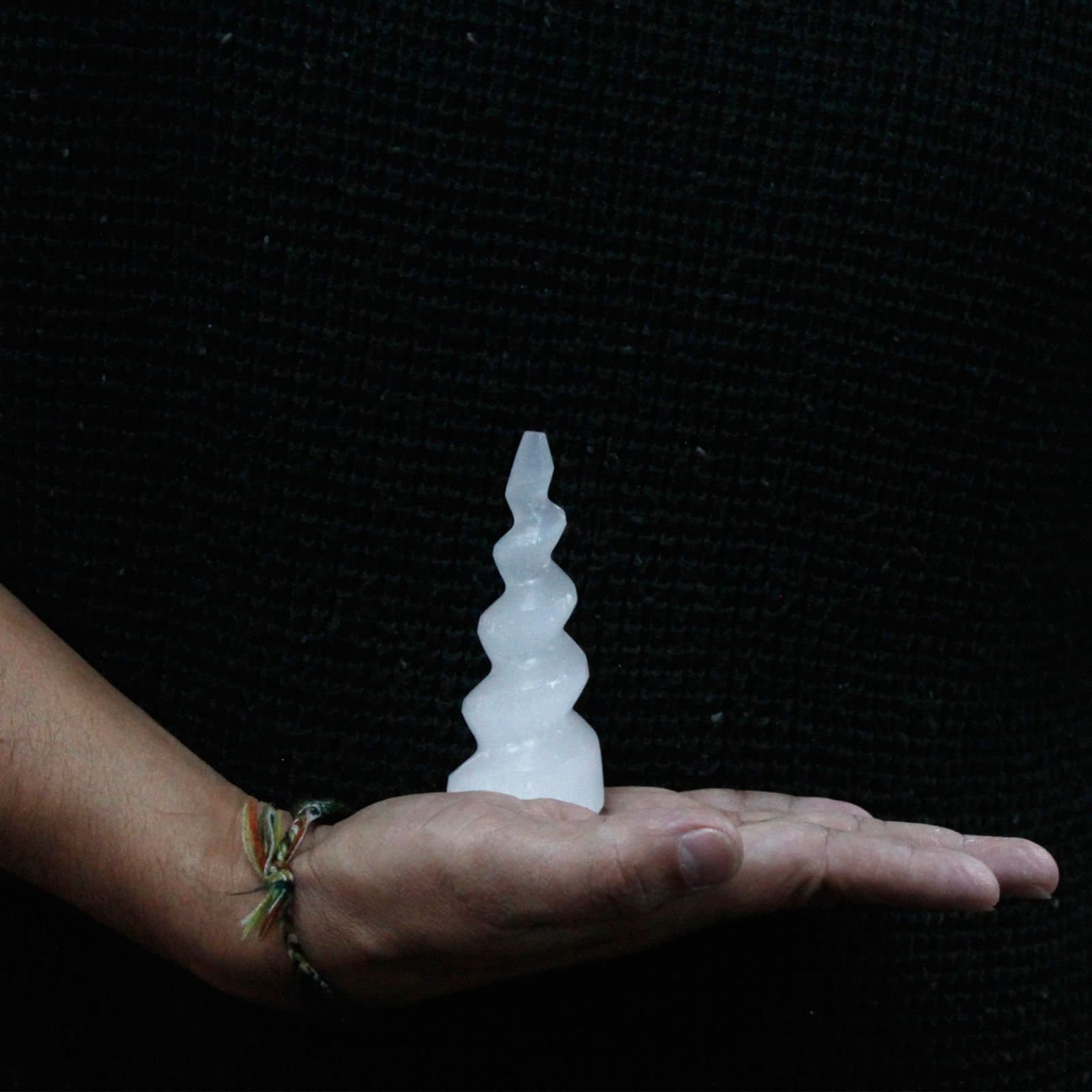 Milky white selenite tower with a spiral unicorn horn shape