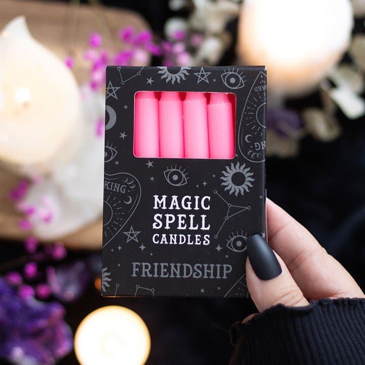 Pack of 12 pink friendship spell candles in a picture box with a window