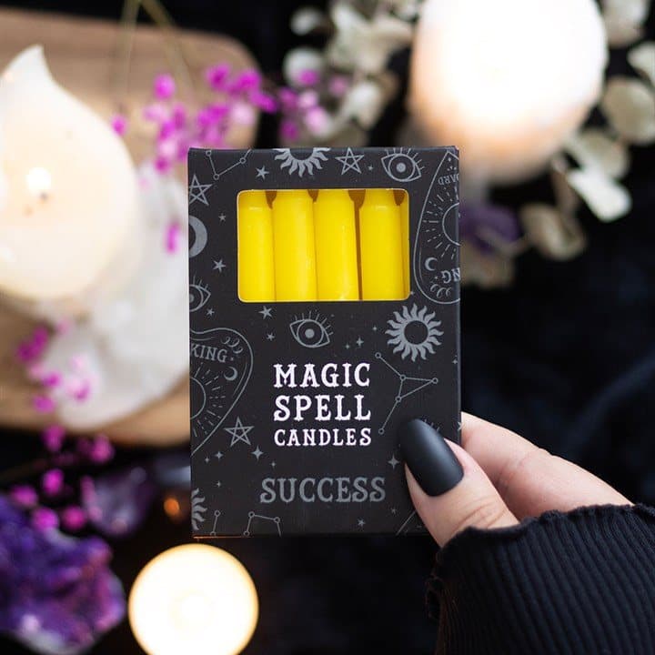 Pack of 12 yellow spell candles in a picture box with a window