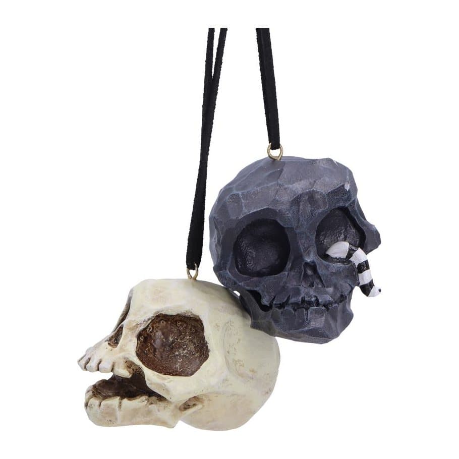 Black and white skull hanging ornaments, the black one with a worm in its eye socket